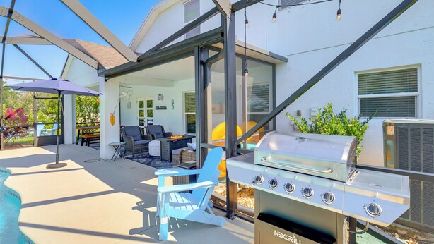 Ein Garten mit Grill, Sitzgelegenheit und Pool.