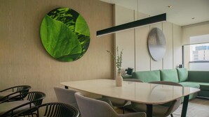 Un espace repas moderne avec une table ronde, des chaises et un canapé vert.
