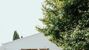 A modern house with a white exterior, a wooden staircase, and a small garden area. - Grand Juste (Marseille)