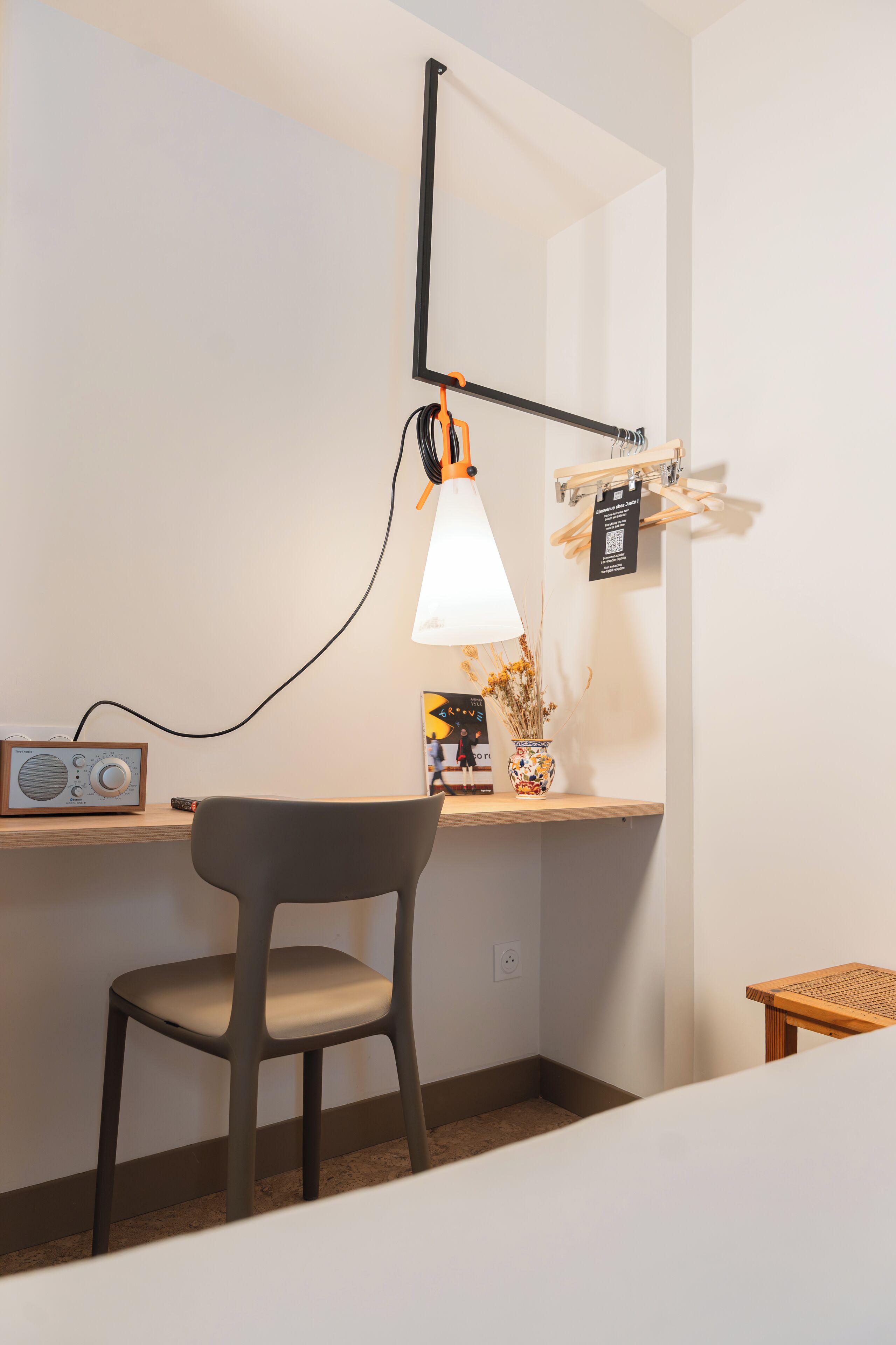 A workspace with a desk, chair, lamp, radio, and decorative items.