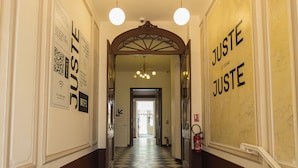 A hallway with a checkered floor, white walls, and hanging lights. - Grand Juste (Marseille)
