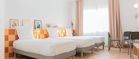 A modern hotel room with two beds, a desk, and a chair.