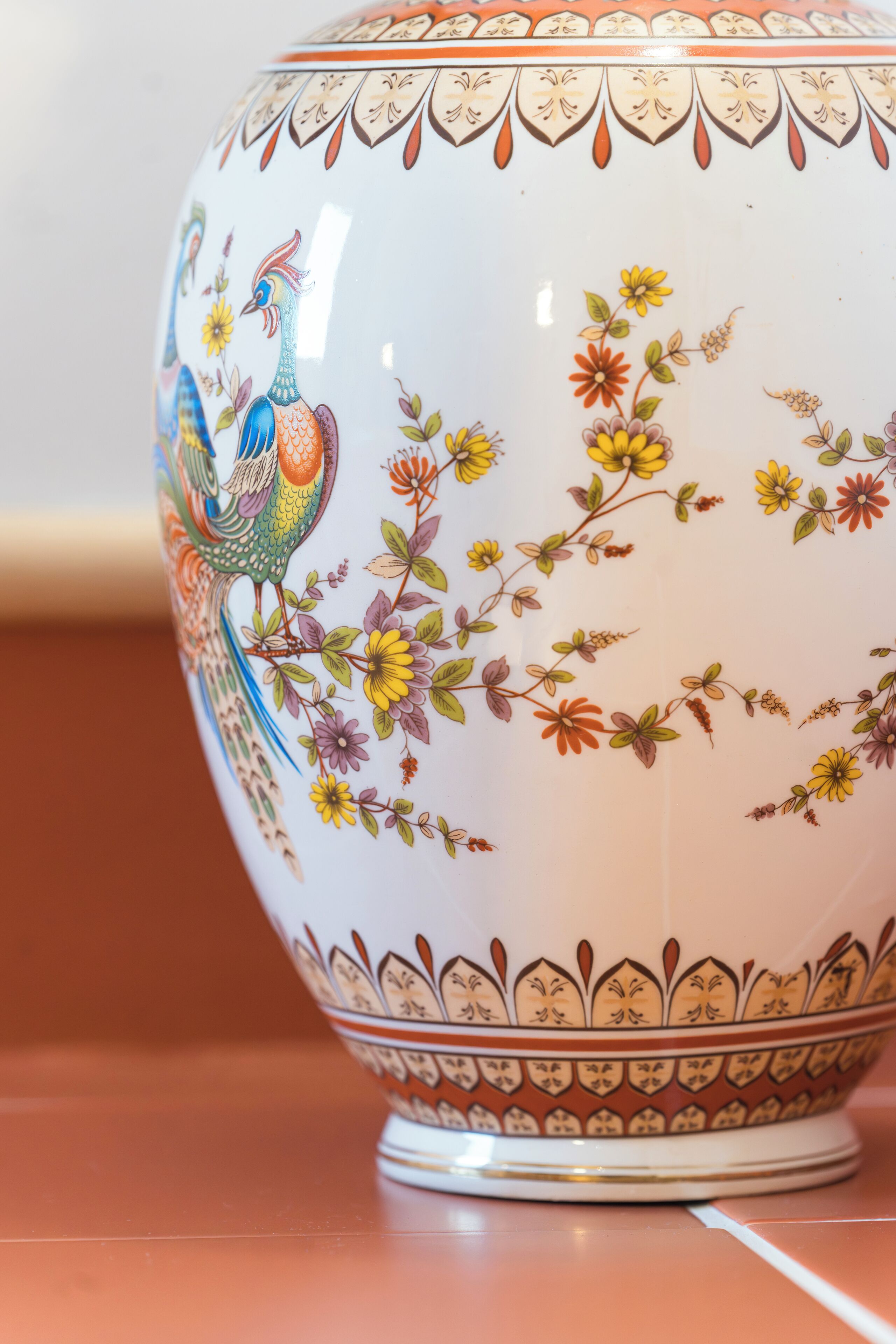 A white ceramic bowl with colorful floral and bird designs.