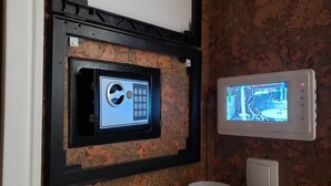 Een beveiligingspaneel met een keypad en een bewakingscamera, bevestigd aan een bakstenen muur.