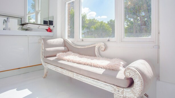 A white, ornate sofa with a fluffy throw blanket in a bright room with large windows and a mirror. - HUGE 5 floors townhouse in central London NW6 (London)
