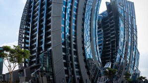 Un rascacielos moderno de diseño arquitectónico único, con ventanas de vidrio reflectante y forma curvada.