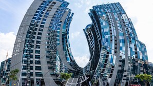 Un edificio moderno con un diseño curvo distintivo, con múltiples ventanas de vidrio y fachada reflectante.