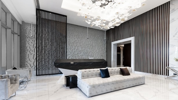 A modern lobby with a white sofa, a black accent piece, and a unique ceiling light fixture. - LUX Waterfront 1BR Near B.khalifa (Dubai)