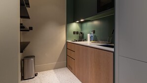 Een moderne keuken met een roestvrijstalen spoelbak, houten kastjes en een ingebouwde magnetron.