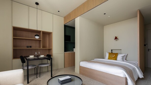 Een moderne hotelkamer met een bed, bureau en stoel.