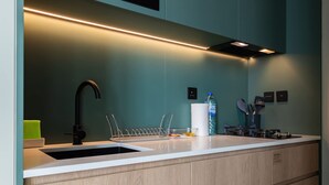Een moderne keuken met een wit aanrecht, een zwarte kraan en een inbouwoven.