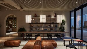 A modern interior with a long dining table, leather sofas, and a large window offering a city view. - Deluxe Studio With Balcony Full Burj Khalifa View (Dubai)