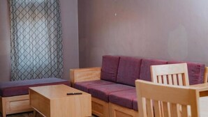 Ein gemütliches Zimmer mit einer Holzsofa, einem passenden Holzstuhl und einem kleinen Holztisch.