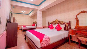 A hotel room with two beds, a wooden dresser, a mirror, and a desk. - OYO 1140 Maganda Hotel (Tagaytay)