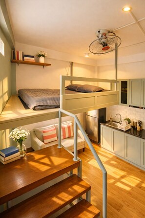 A bunk bed with a desk and chair, a kitchen area, and a small seating area with a plant. - Signy House Hotel & Apartments Bach Dang River - Doan Nhu Hai (Ho Chi Minh City)
