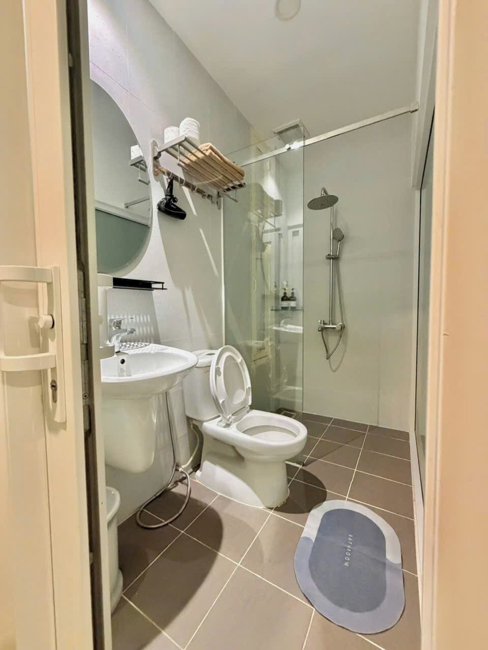 A modern bathroom with a toilet, sink, and shower.