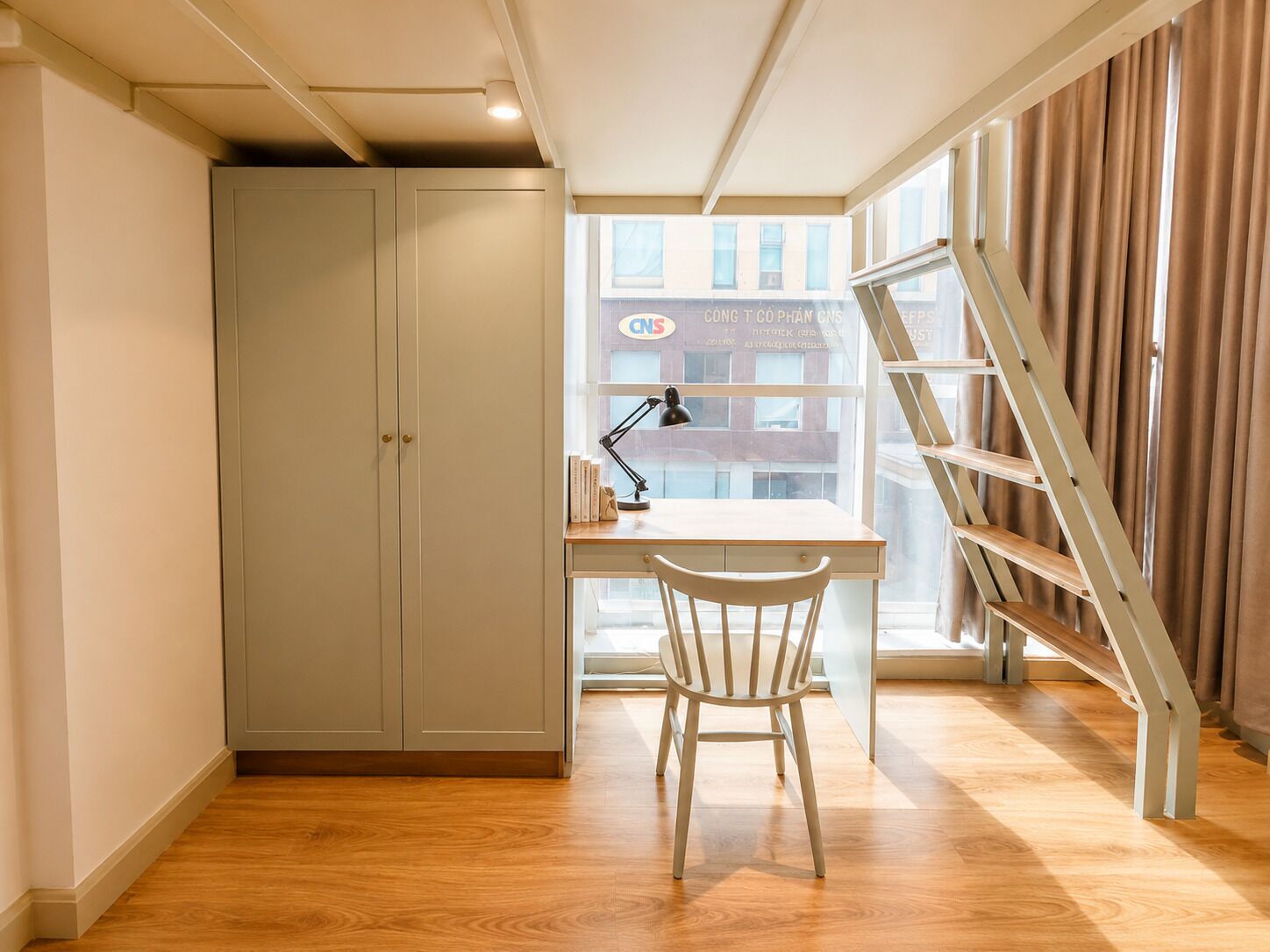 Une pièce avec un bureau, une chaise et une échelle appuyée contre une fenêtre.
