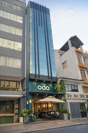 A modern building with a restaurant named 'odo' at the ground level, featuring outdoor seating and a visible entrance. - Signy House Hotel & Apartments Bach Dang River - Doan Nhu Hai (Ho Chi Minh City)