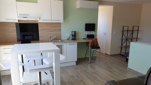 Una cucina moderna con mobili bianchi, forno integrato e macchina per il caffè.