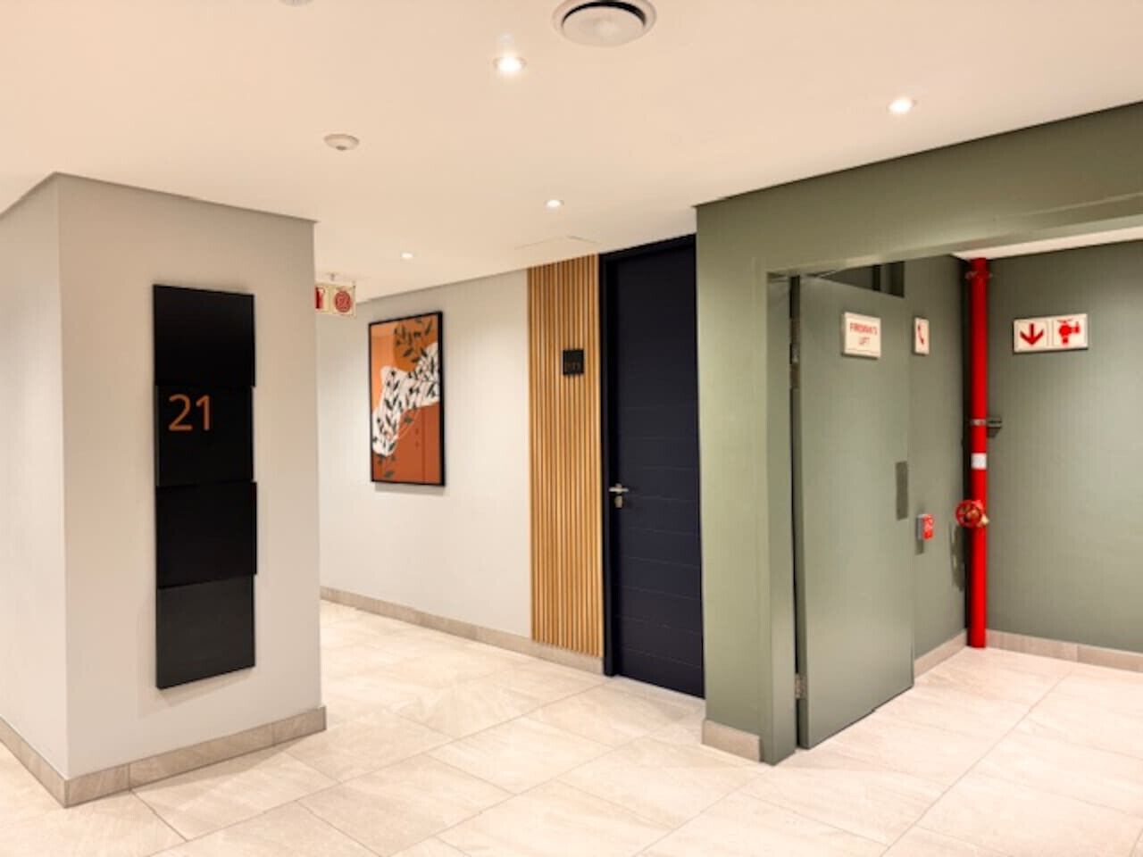 A hallway with a number sign, a door, and a fire extinguisher.