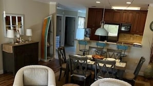 A living room with two armchairs, a coffee table, and a dining area with a table and chairs. - Ocean Reef 306 3 Bedroom Condo (St. Augustine)