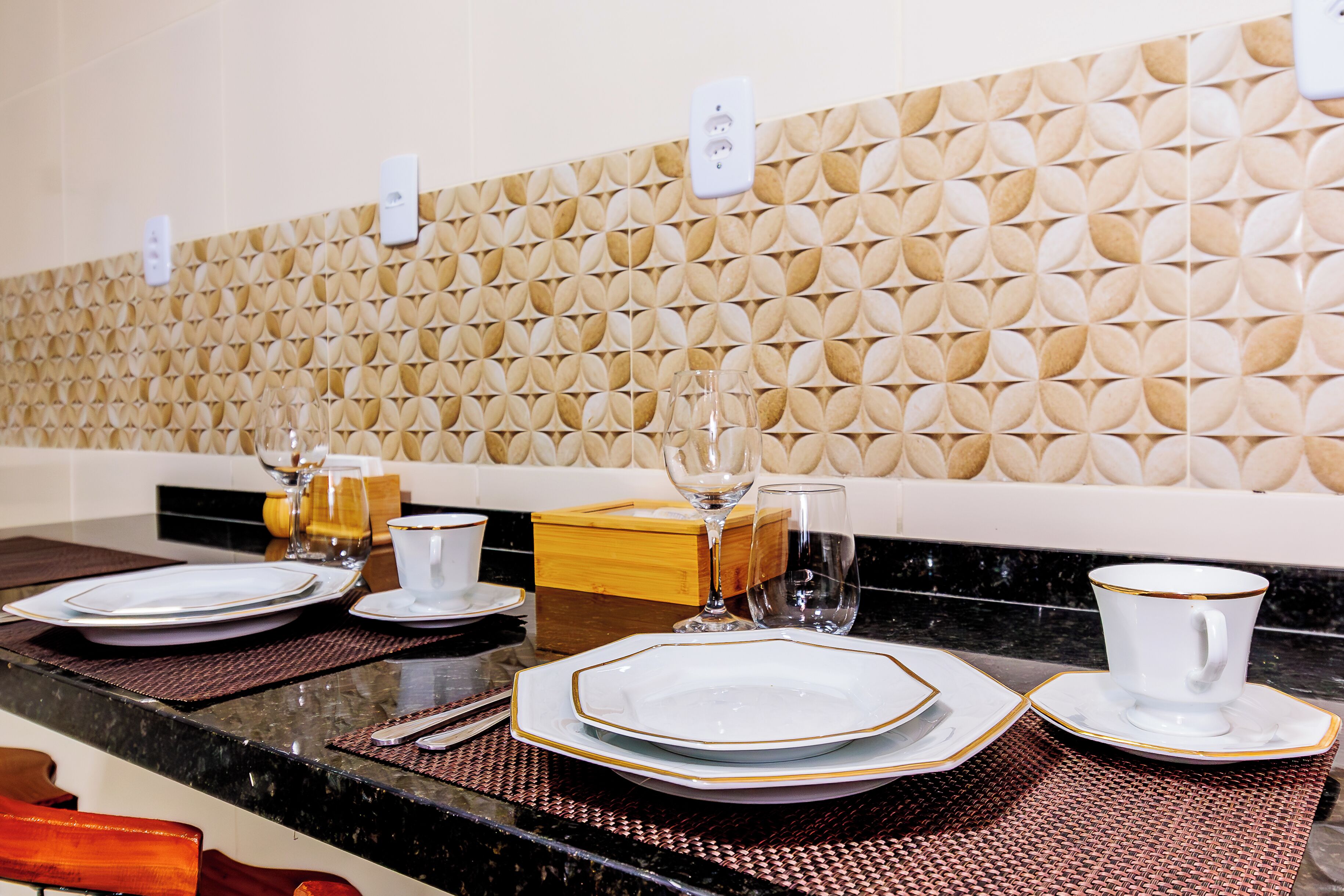 Un comedor de hotel con una pared estampada, una barra de buffet y una encimera de mármol negro.