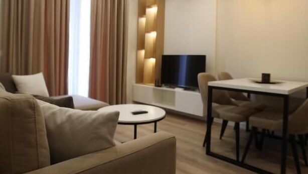 Ein modernes Wohnzimmer mit einer Couch, einem Esstisch und einem Fernseher.