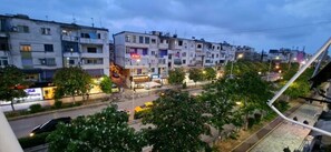 A multi-story urban building with balconies, a street in the foreground, and trees. - Arkle Apartment 1 (Tirana)