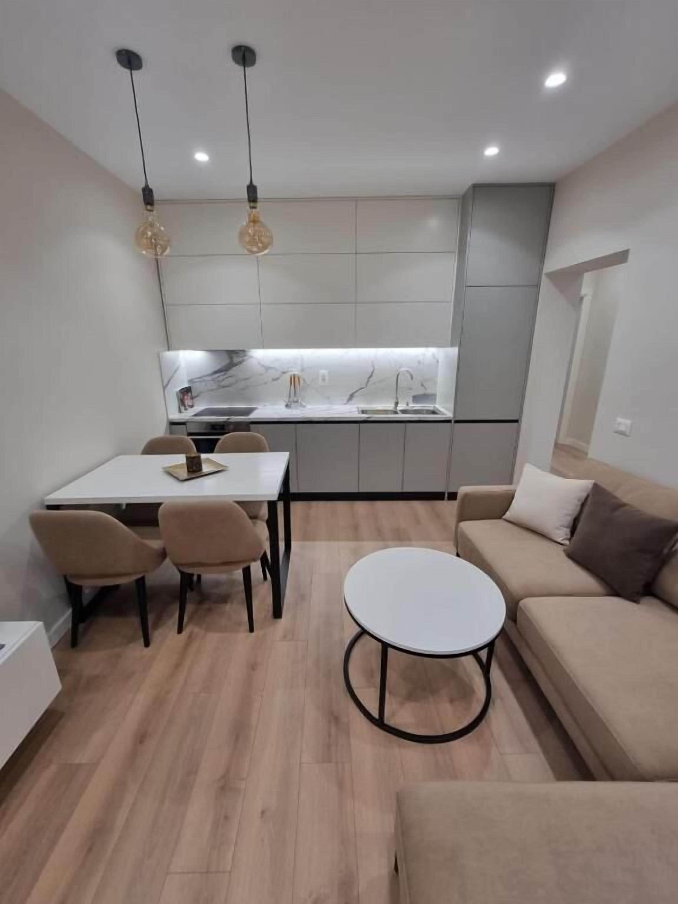 En moderne stue med spiseplads, en sofa og et rundt sofabord.