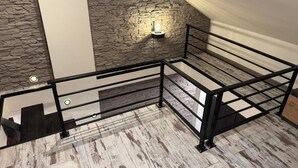 A staircase with a stone wall and a modern light fixture. - Carpatia Loft (Unknown)