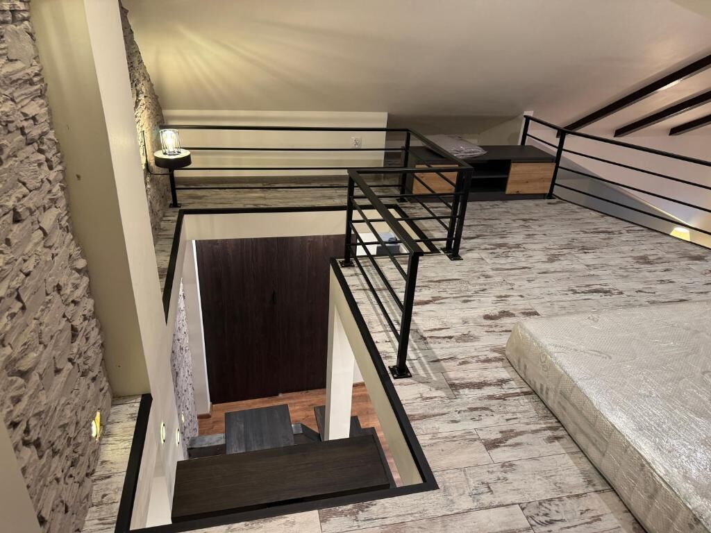 Ein modernes Interieur mit Treppe, Steinwand und einem Bett.