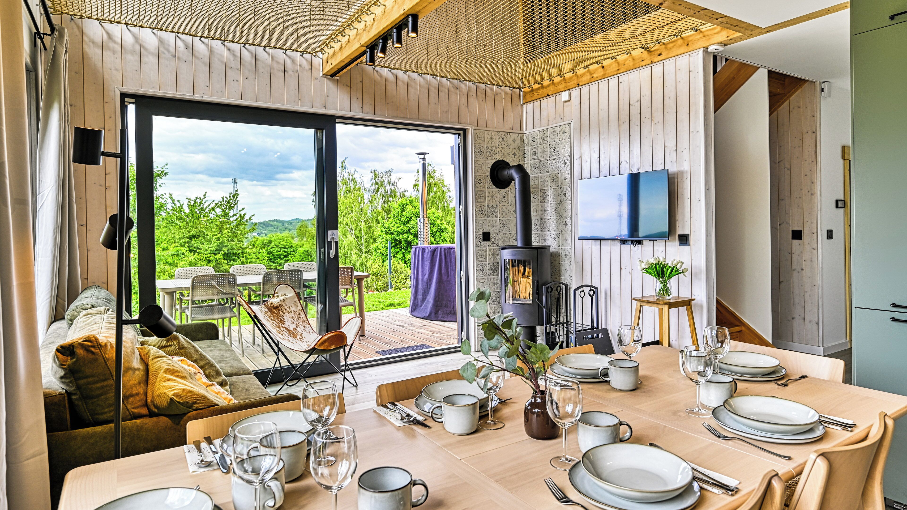 A cozy dining area with a table set for four, a sofa, and a view of the outdoors.