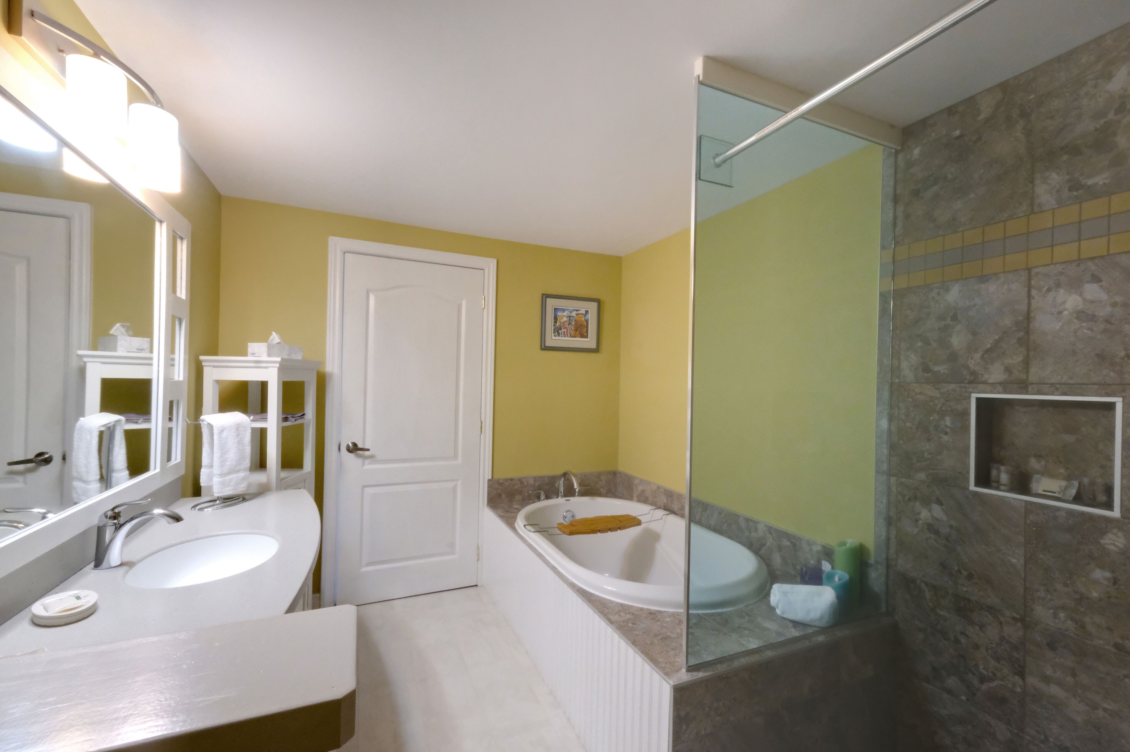 A bathroom with two sinks, a bathtub, and a shower area.