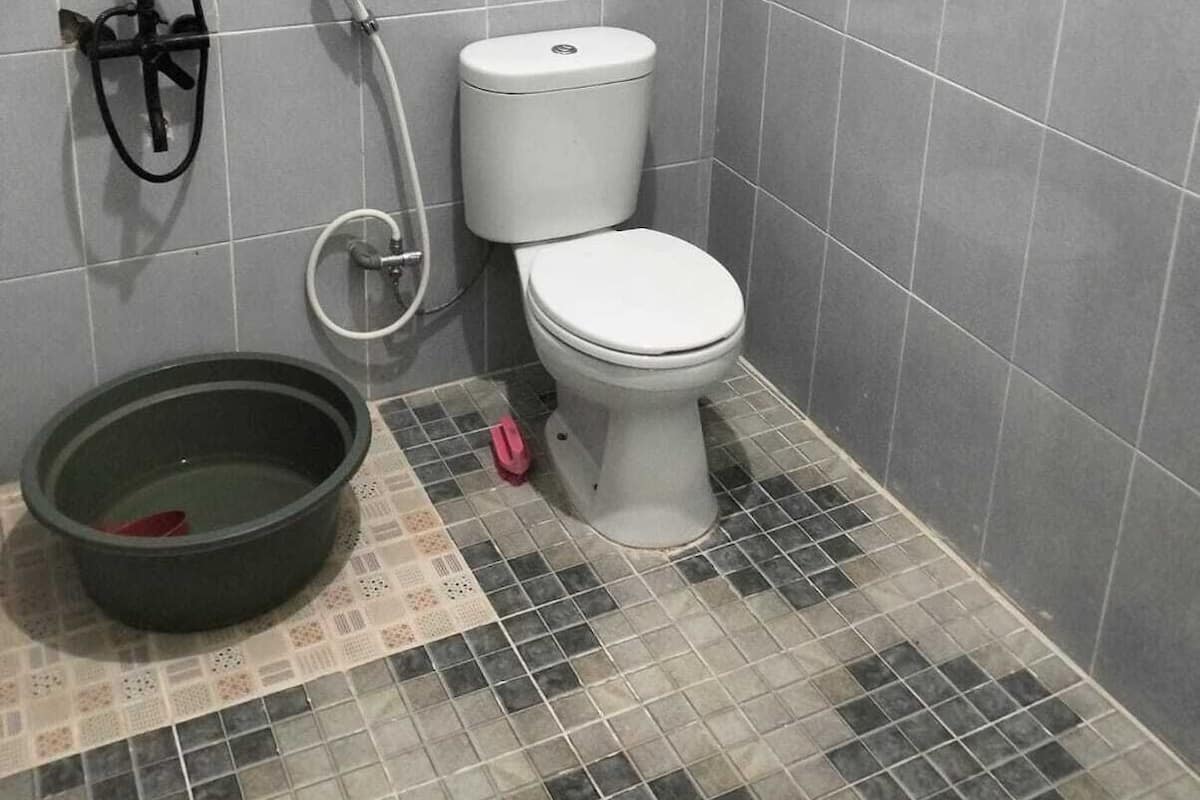 A bathroom with a toilet, a shower, and a bidet.