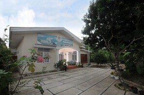 Ein zweistöckiges Haus mit einer überdachten Terrasse und einem großen Wandgemälde an der Vorderseite.