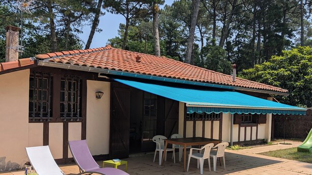A house with a tiled roof, a covered patio with a table and chairs, and a small garden area. - Typical Landes villa Seignosse le Penon (Seignosse)