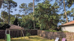A backyard with a swing set, a slide, and two lounge chairs. - Typical Landes villa Seignosse le Penon (Seignosse)