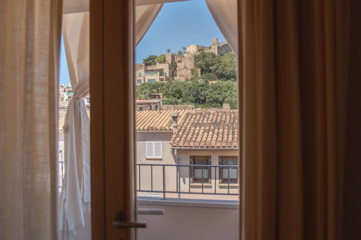 Un balcon offrant une vue sur une ville historique et un château.