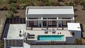 A modern two-story house with a swimming pool, outdoor seating, and a fenced patio area. - Valley View 2 Bedroom Villa with Private Pool (Zakinthos)