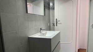 A bathroom with a white sink, a mirror, and a door. - B&B Anna e Gaetano (Meta)