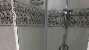 A glass-enclosed shower with a handheld showerhead and a wall-mounted faucet. - B&B Anna e Gaetano (Meta)