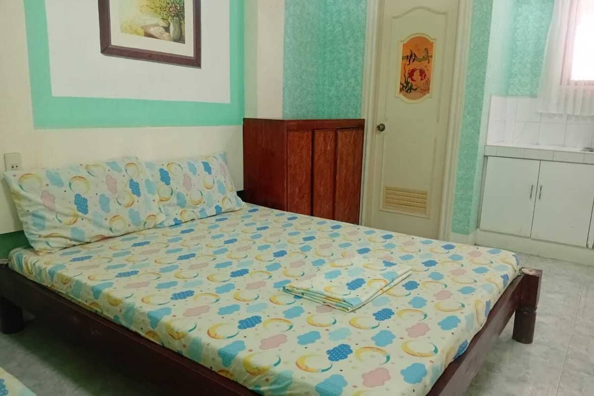 A bedroom with a bed, a wardrobe, and a door with a decorative plate.