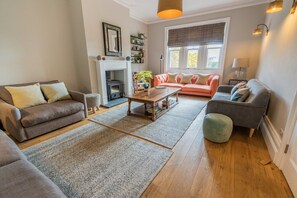 A cozy living room with a fireplace, a sofa, a coffee table, and a bookshelf. - Eastfield Lodge - Perfect Group accommodation (Leyburn)