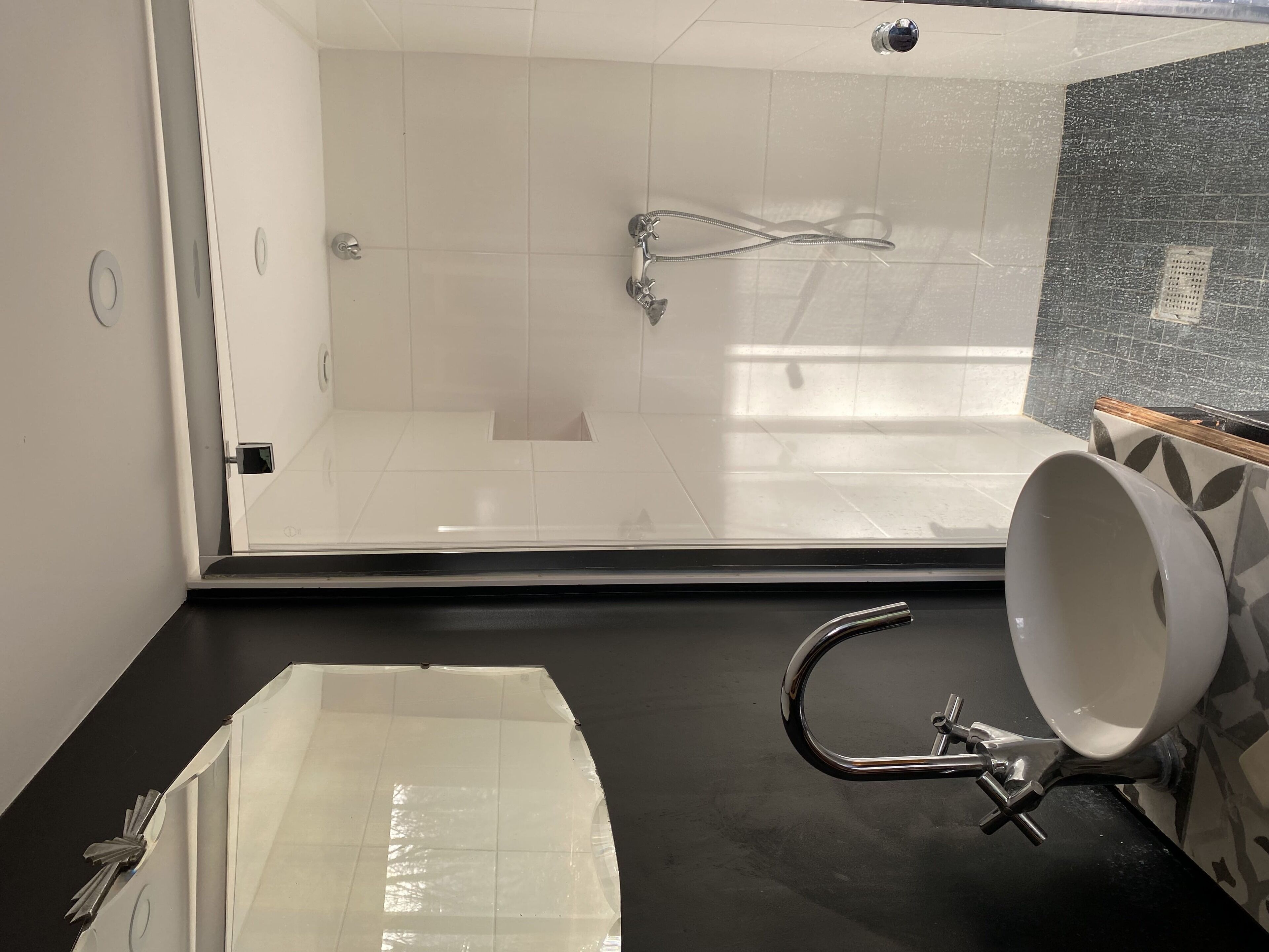 A modern bathroom with a glass shower enclosure, a large bathtub, and a sink with a mirror.