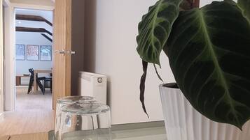 Een moderne kamer met een houten tafel, een potplant en een witte radiator.