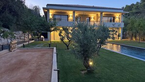 A modern house with a swimming pool, surrounded by well-maintained grass and trees. - Elegant new 250 m² duplex with garden, swimming pool and spa, a stone's throw from the center of town (Aix-en-Provence)
