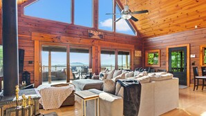 Une cabane spacieuse dotée d’un grand salon, d’une cheminée et d’une terrasse offrant une vue sur les montagnes.