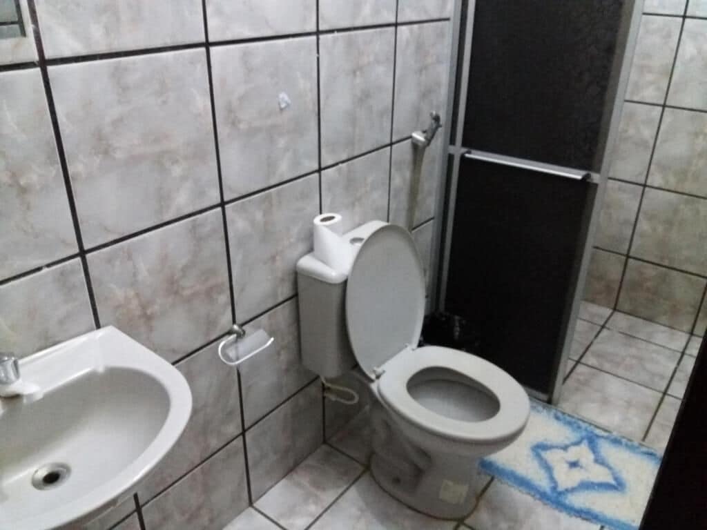 A bathroom with a toilet, sink, and tiled walls.