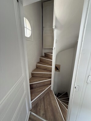 A staircase with wooden steps and white walls, leading to a door. - Charming townhouse, fully equipped, 2 steps from shops (Grand-Couronne)