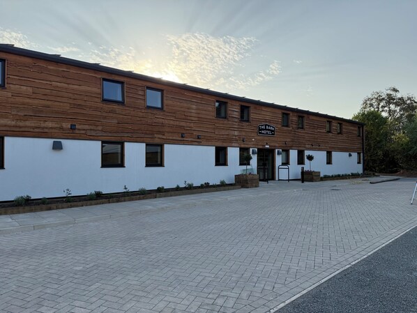A modern building with a wooden facade and a sign reading "The Barn Hotel". - The Barn Hotel (Solihull)